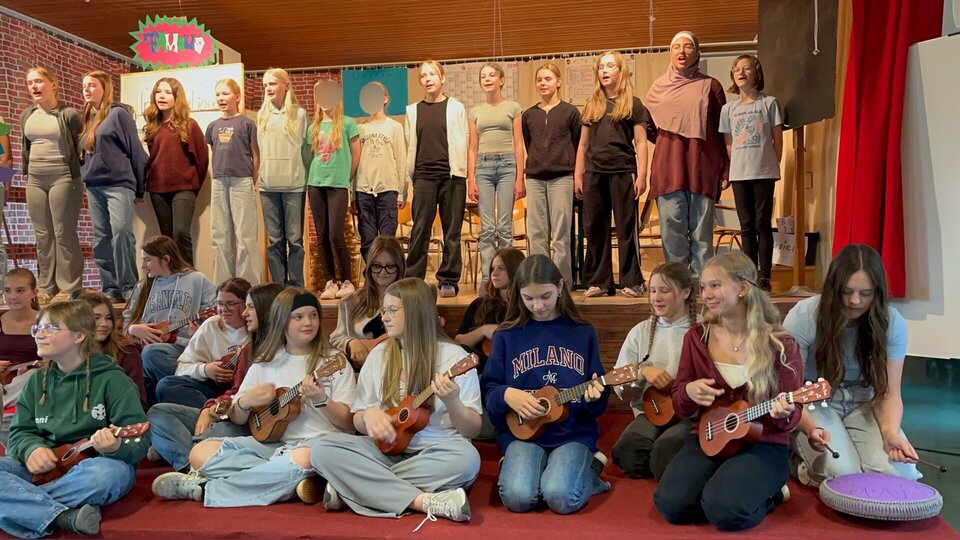 Schülerinnen begrüßen das Publikum im Musiksaal