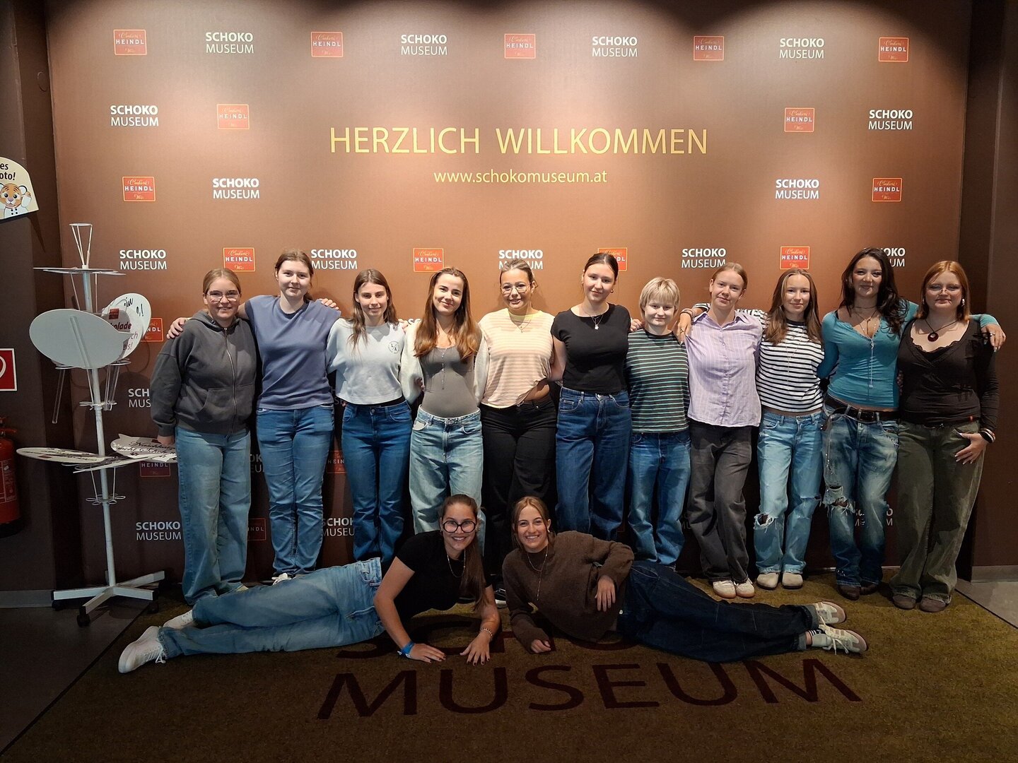 Die Schülerinnen der 10. Klasse posieren gemeinsam vor dem Eingang des Schokomuseums in Wien