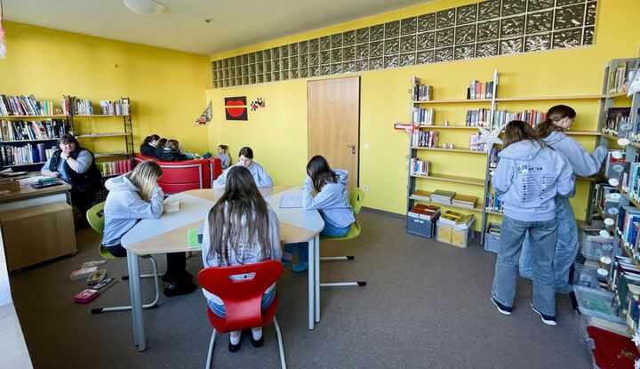 Bibliothek mit Schülerinnen und Erzieherin